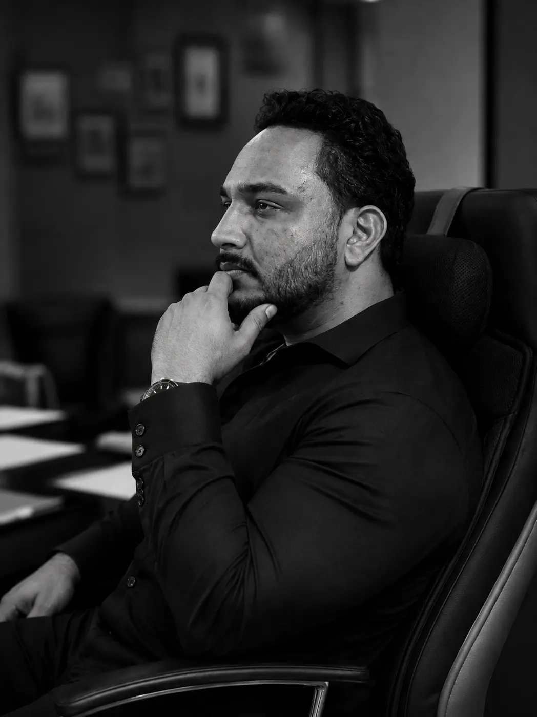 Leonardo Viana, em preto e branco, pensativo durante uma reunião.